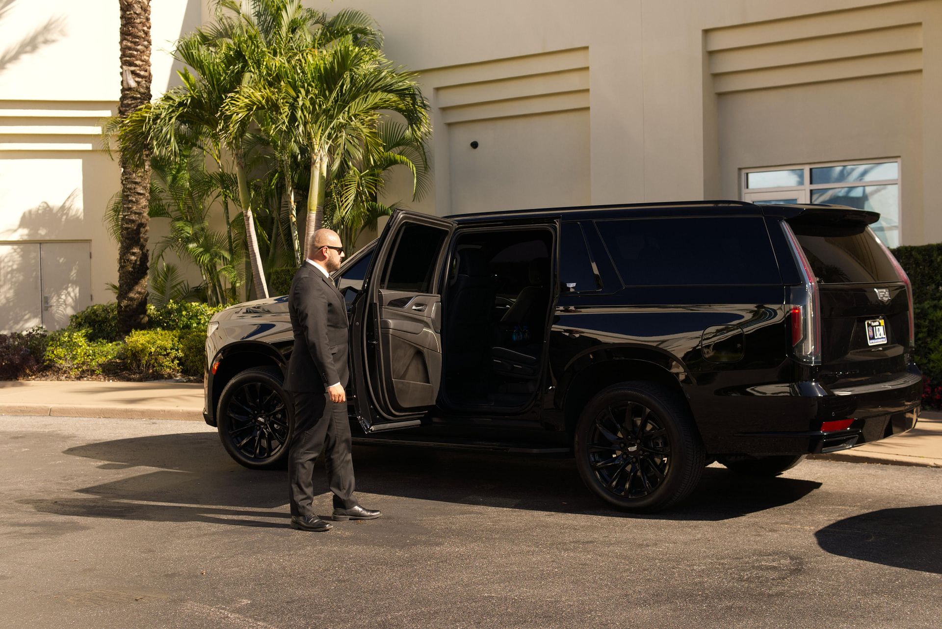 Chauffeur beside a black executive SUV ready for a Toronto journey